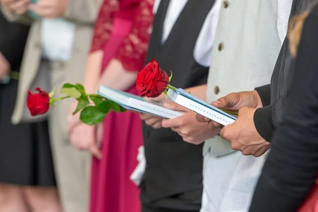 Jugendliche mit Urkunden und roten Rosen bei ihrer Jugendweihe